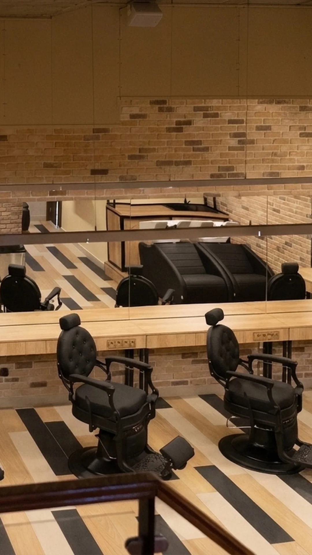 Interiorul Contour Collective din Cluj-Napoca, cu scaune de frizerie și pereți de cărămidă aparentă